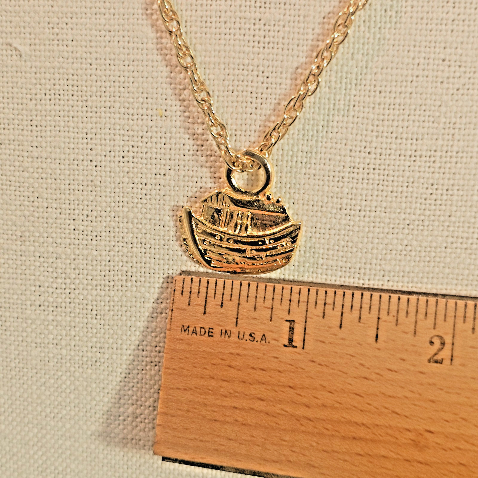 Bright gold tone Noah’s Ark pendant and 24 inch gold tone chain necklace