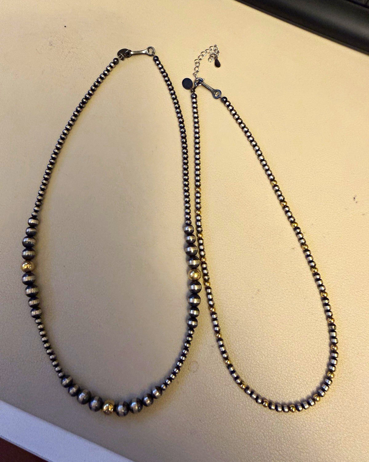 sterling silver with gold plated pearls I believe they’re both 16 inches
