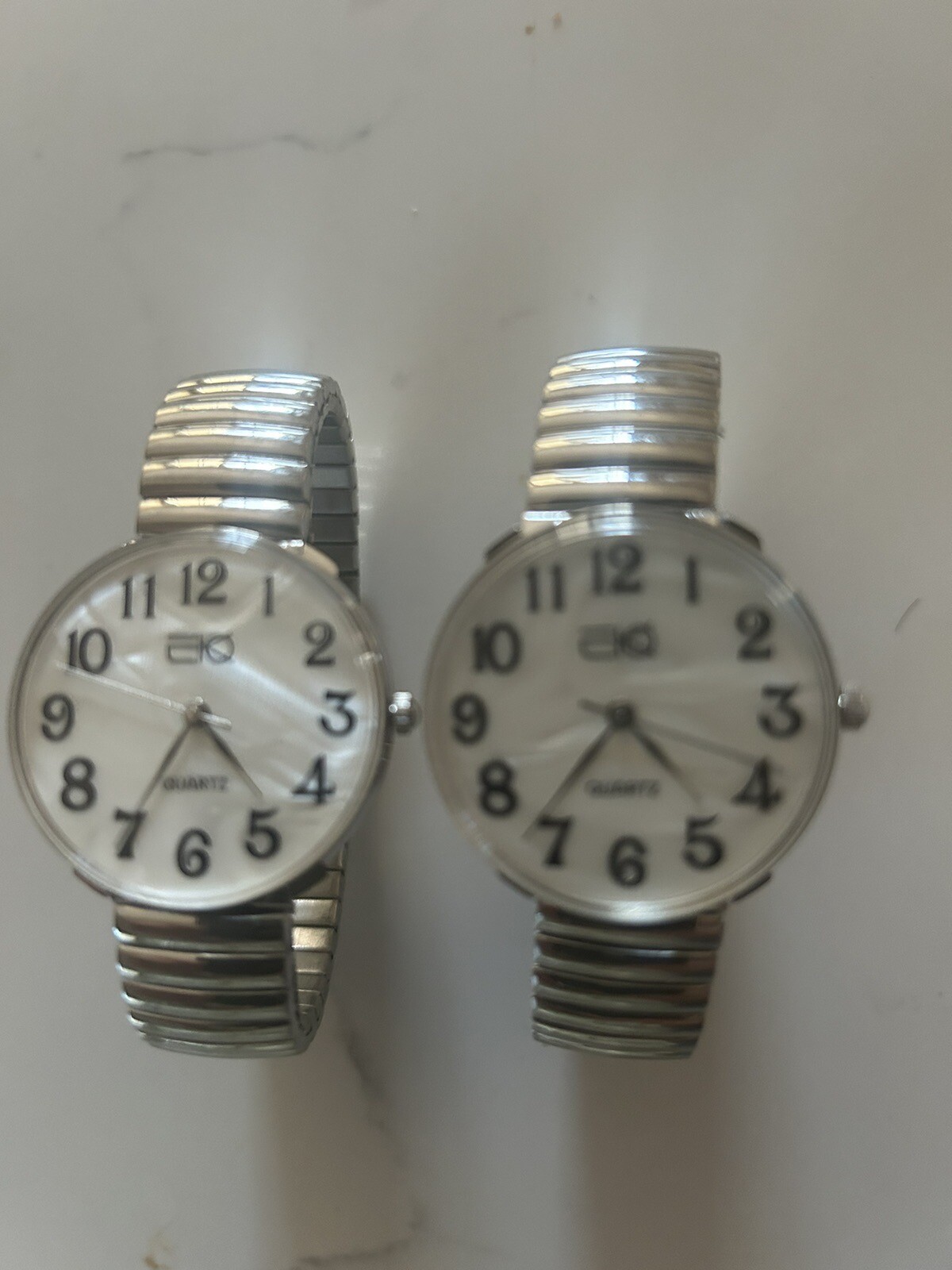 Buyer gets 2 new silver stretch band watches with large easy to read numbers