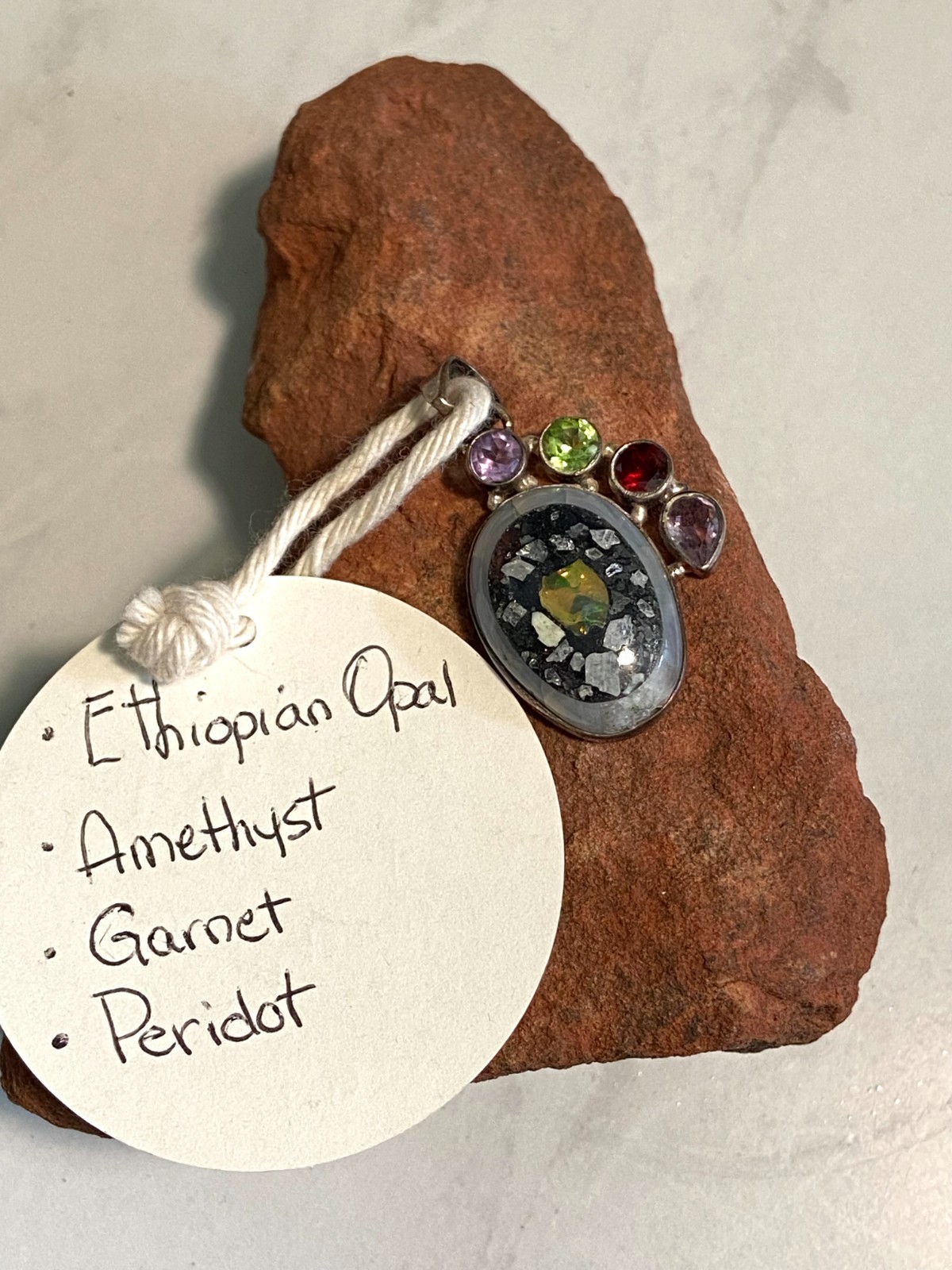 Ethiopian Opal Pendant with Amethyst, Ruby and Peridot accent stones.