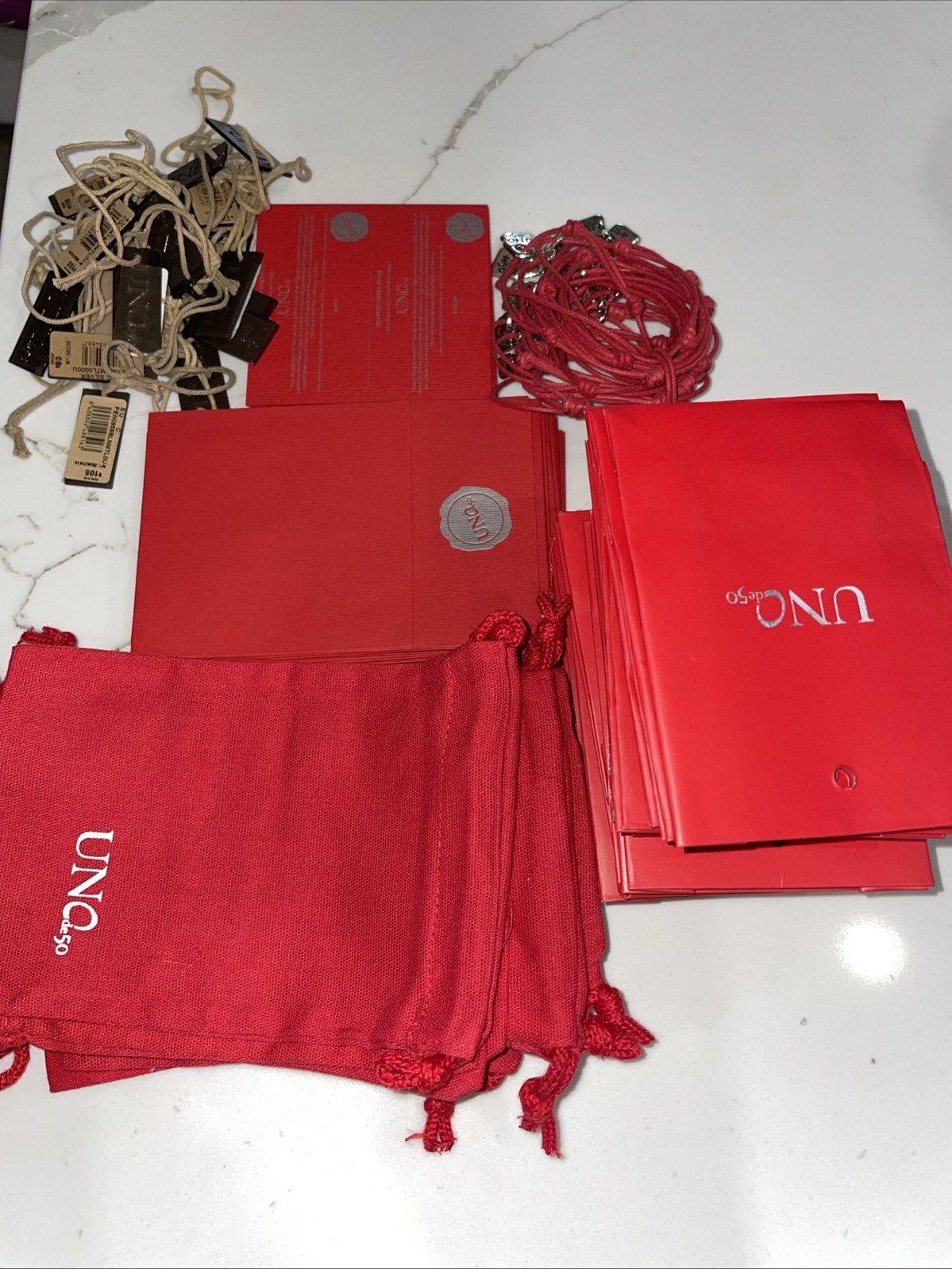 UNO de 50 packaging 10 Cloth Bags 18 Bags 25 Warranty, 25 Tags & 25 Bracelets