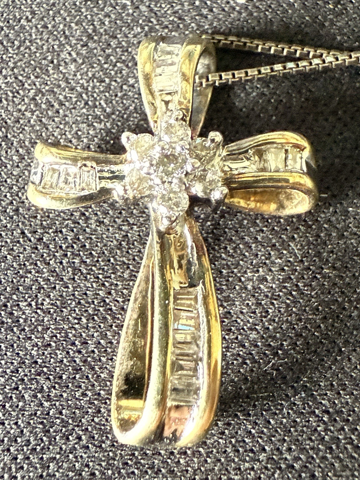 This is a cross necklace featuring baguette and round diamonds.