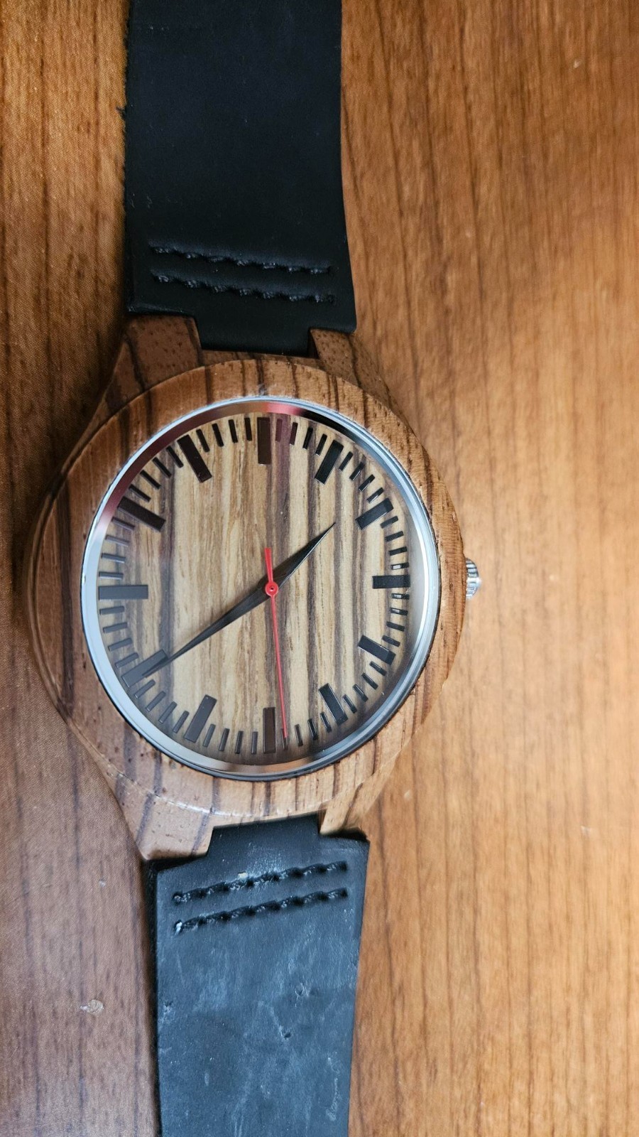 Men’s watch made of wood, engraved for Fathers Day. Band appears to be leather