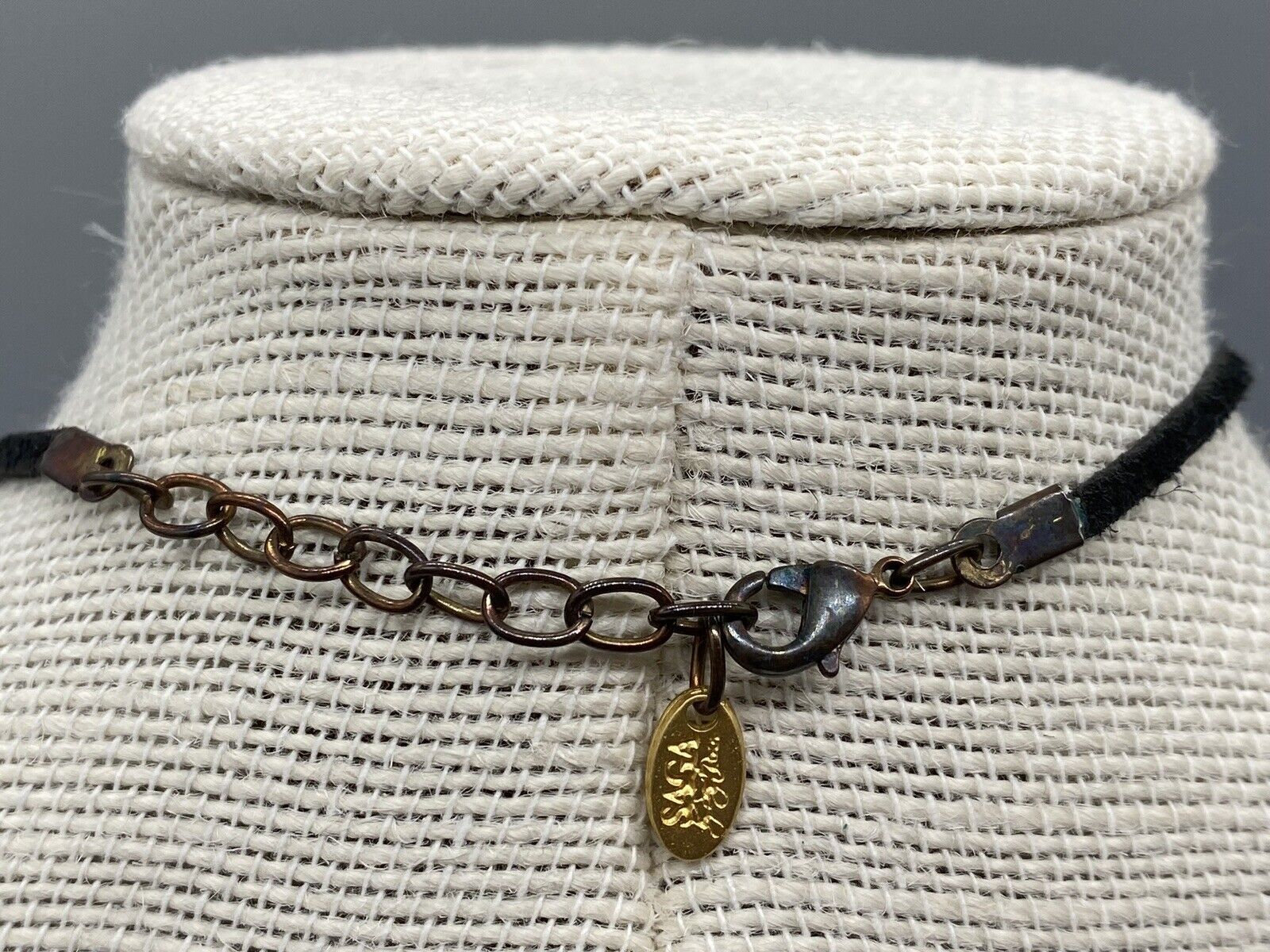 SAGA HIEROGLYPH GOLD TONE ROUND PENDANT BLACK LESTHER NECKLACE
