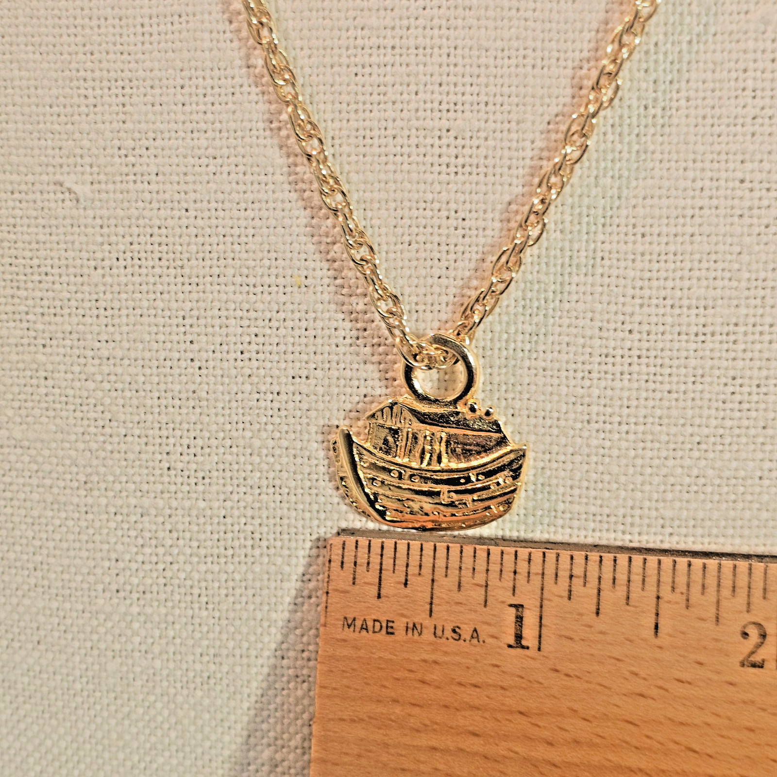 Bright gold tone Noah’s Ark pendant and 24 inch gold tone chain necklace