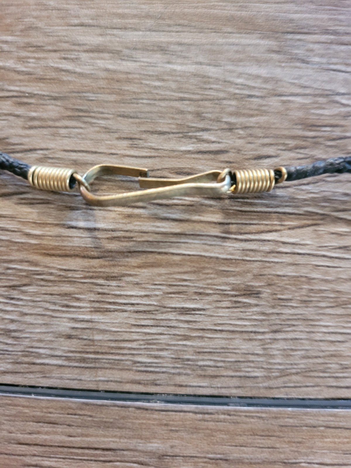 handmade artisan necklace pendant with a textured wood grain finish on a Cord