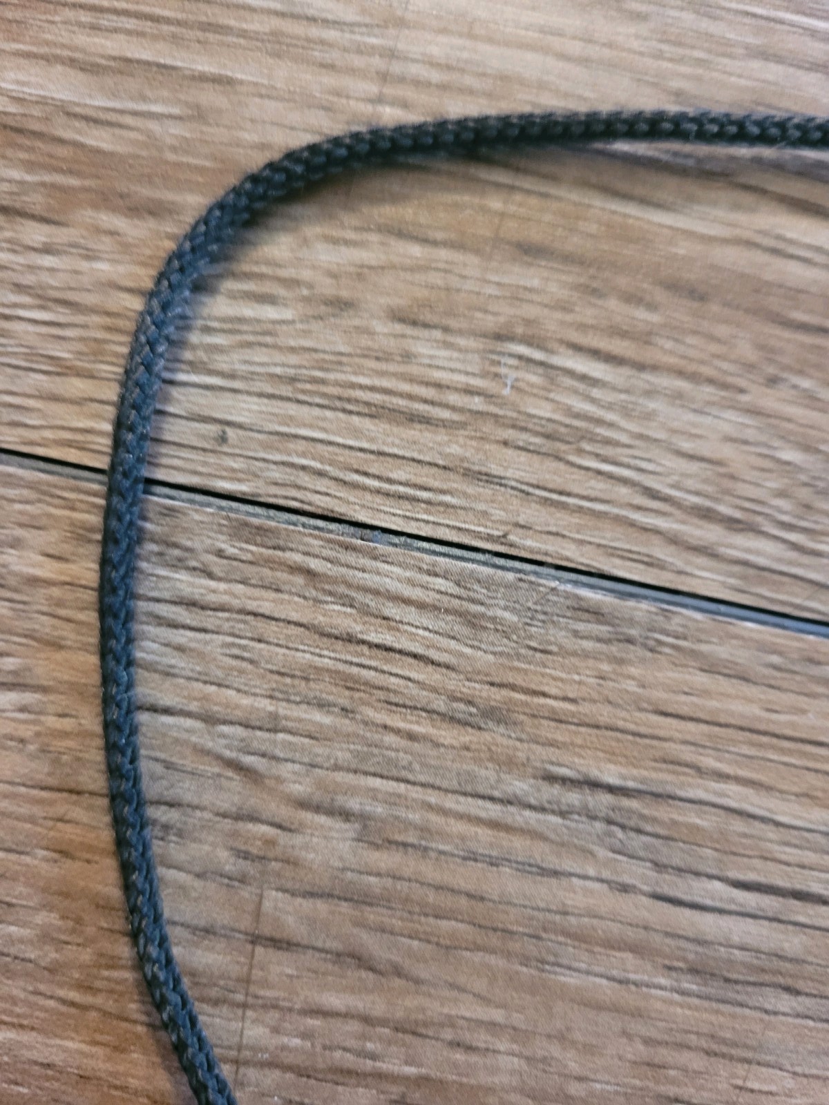 handmade artisan necklace pendant with a textured wood grain finish on a Cord