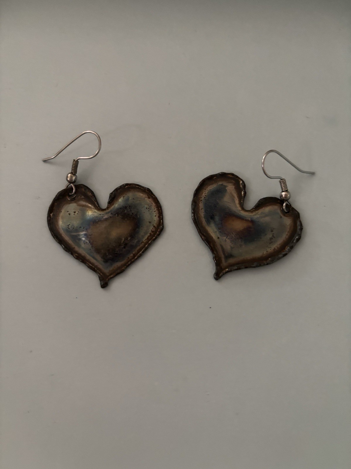 Flame painted copper heart earrings with a unique rainbow patina created by heat
